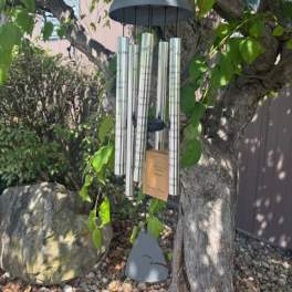Wind chime hanging from a tree branch outdoors