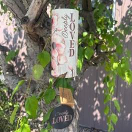 Decorative memorial sign hanging from a tree branch