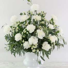 White flowers arranged in a white pedestal vase