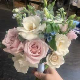 Handheld bouquet of blush and white roses with large white blooms