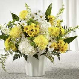 Yellow and white flower arrangement in a white vase