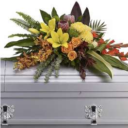 Colorful floral spray arranged on a silver casket