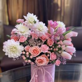 Pink and white bouquet in a pink hatbox with tassel cord