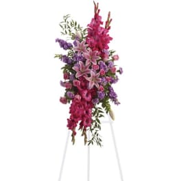 Tall pink and purple floral spray on a white stand