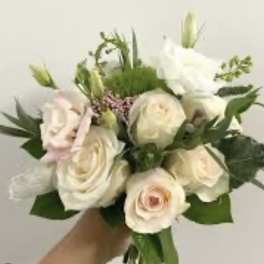 Handheld bouquet of white and blush roses with green buds