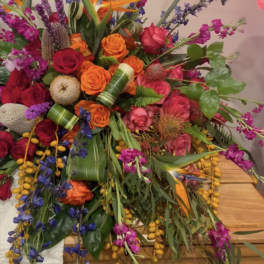 Large bouquet of orange, pink, and purple flowers with tropical blooms