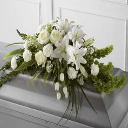 White floral casket spray with roses and lilies