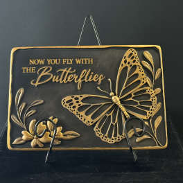 Decorative plaque with a gold butterfly and floral accents
