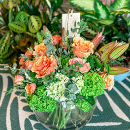 Peach roses and green hydrangeas in a clear glass vase