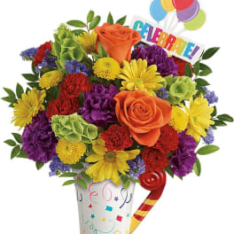 Colorful bouquet in a party cup with balloons and a "Celebrate!" sign