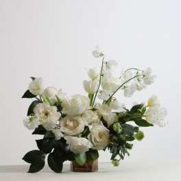 White floral arrangement in a low glass vase