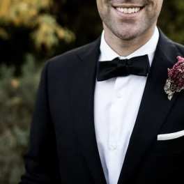Man in tuxedo wearing a pink boutonniere on his lapel