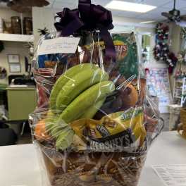 Gift basket with bananas, chips, and candy wrapped in cellophane