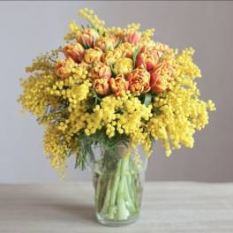 Yellow and orange tulips in a clear glass vase