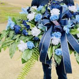 Large blue and white floral spray with a navy ribbon bow