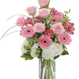 Pink roses and gerbera daisies in a clear glass vase