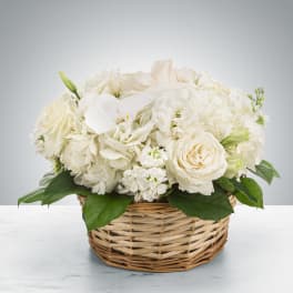 White roses and hydrangeas in a wicker basket