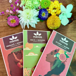 Three chocolate bars with colorful flower accents on a wooden surface.