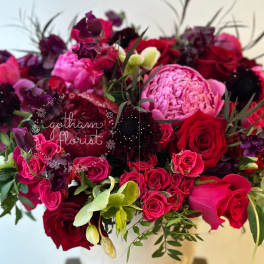 Bouquet of red, pink, and purple flowers in a white vase