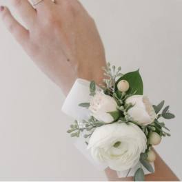 White and blush wrist corsage with round white bloom and buds on a white band