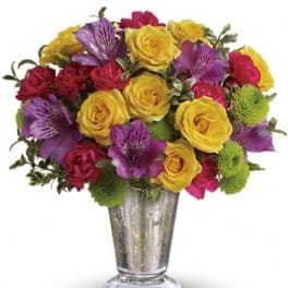 Bouquet of yellow roses, purple alstroemeria, and pink flowers in a silver vase