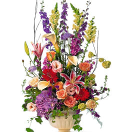 Tall mixed flower arrangement in a cream urn vase