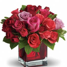 Bouquet of red and pink roses in a red glass vase