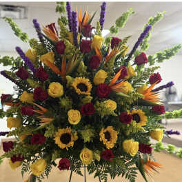 Large mixed bouquet with red and yellow roses, sunflowers, and purple spikes