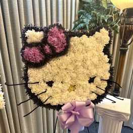 Cat-shaped floral standing spray with pink and cream carnations