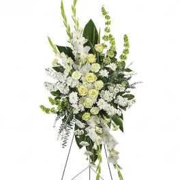 Tall white and pale yellow funeral spray on a stand