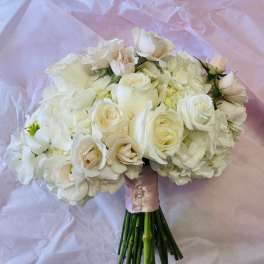 White rose and hydrangea bouquet wrapped in pink paper