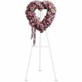 Pink floral funeral wreath on a white easel