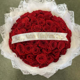 Bouquet of red roses wrapped in white paper with a ribbon