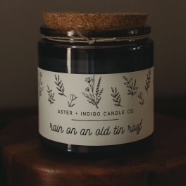 Black candle jar with a cork lid and floral label