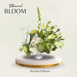 Green and white floral arrangement with lilies and roses in a white vase