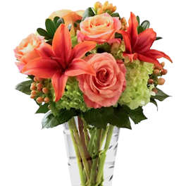 Pink roses and red lilies in a clear glass vase
