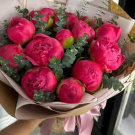 Bouquet of bright pink peonies wrapped in pale paper