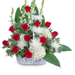 Red roses and white flowers arranged in a white basket