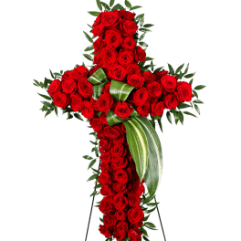 Cross-shaped arrangement of red roses with green foliage on a stand
