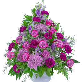 Pink and purple floral arrangement in a white vase