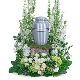 White floral funeral urn arrangement with a silver urn centerpiece