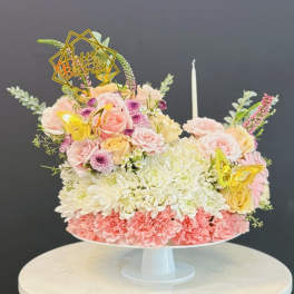 Pastel flower cake with roses, chrysanthemums, and butterfly toppers on a white stand