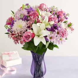 Pink and white mixed bouquet in a purple glass vase