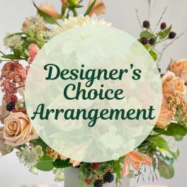 Mixed floral arrangement with roses and peach blooms around a vase