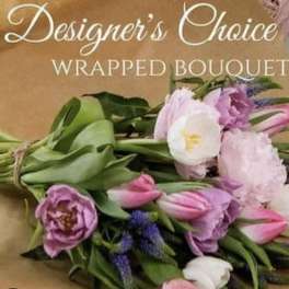 Wrapped bouquet of pink and white tulips with purple flowers