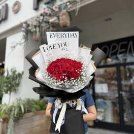 Bouquet of red roses with baby's breath and black-and-white wrapping