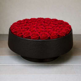 Round black box filled with red roses