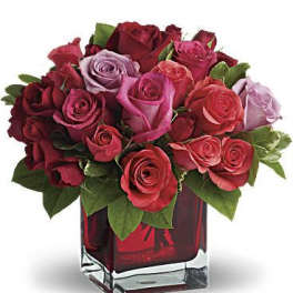 Bouquet of red and pink roses in a square glass vase