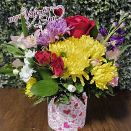 Mixed bouquet of roses, chrysanthemums, and alstroemeria in a Valentine-themed container