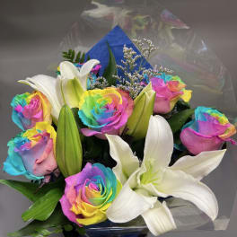 Bouquet of rainbow roses and white lilies in clear wrap